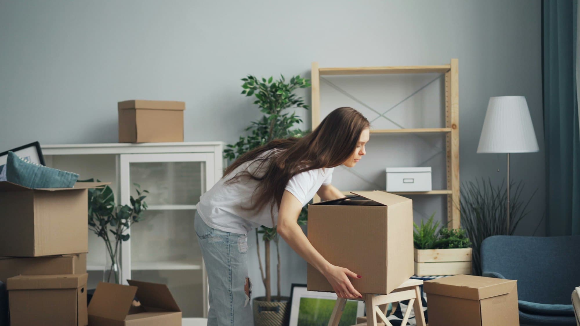 Woman packing moving boxes in a living room